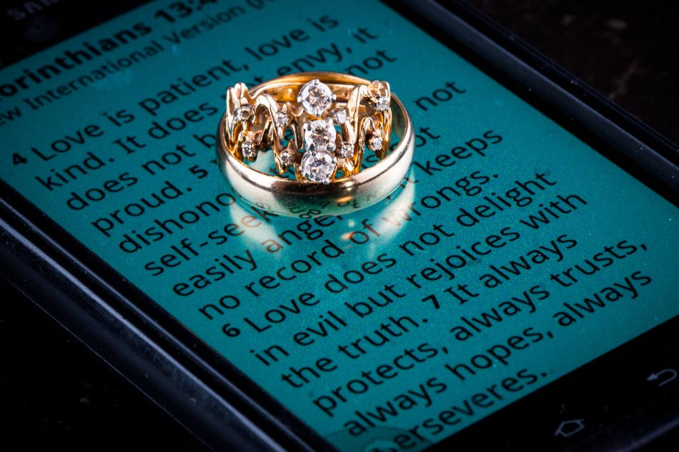 Image of wedding rings on phone showing 1Cor 13